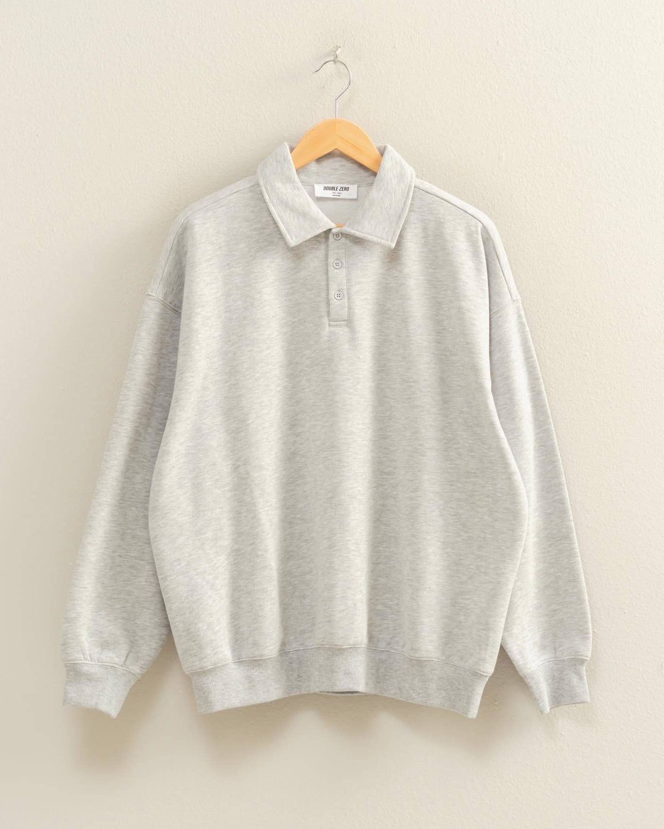 Gray sweater on a hanger against a beige background